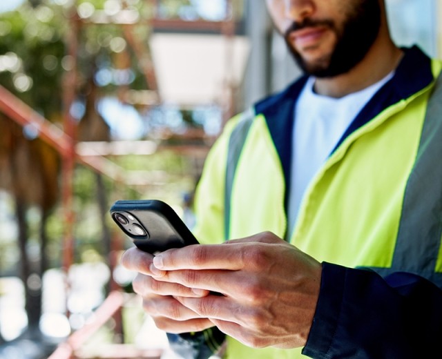 Maintnenance worker checking work orders on mobile device