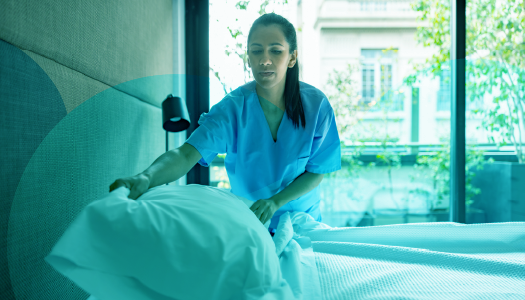 Healthcare worker making a bed.